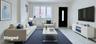 Living area with marble look tiles, a baseboard radiator, baseboard heating, and electric panel