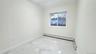 Unfurnished room with light marble finish flooring and a baseboard heating unit