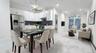 Dining area with light marble finish flooring, a chandelier, a baseboard heating unit, and recessed lighting