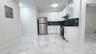 Kitchen with white cabinets, appliances with stainless steel finishes, electric panel, under cabinet range hood, and tasteful backsplash