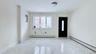 Spare room featuring a baseboard heating unit, light marble finish flooring, and electric panel