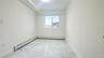 Empty room with a baseboard heating unit and light marble finish flooring