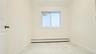 Empty room with light marble finish floors and a baseboard radiator