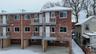 Back of property featuring brick siding and a balcony