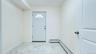 Foyer featuring light marble finish floors and baseboard heating