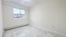 Unfurnished room featuring light marble finish floors and a baseboard heating unit