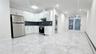 Kitchen with a baseboard radiator, appliances with stainless steel finishes, white cabinets, and light marble finish floors