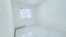Unfurnished room featuring light marble finish floors and a baseboard radiator