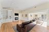 Living room with a wainscoted walls, light wood flooring, and a glass covered fireplace.