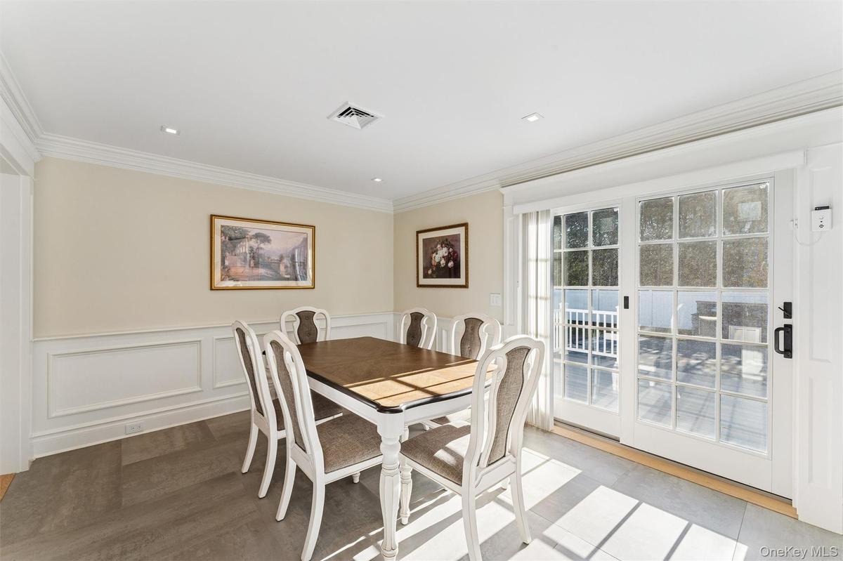 Dining space featuring wainscoted walls and crown molding.