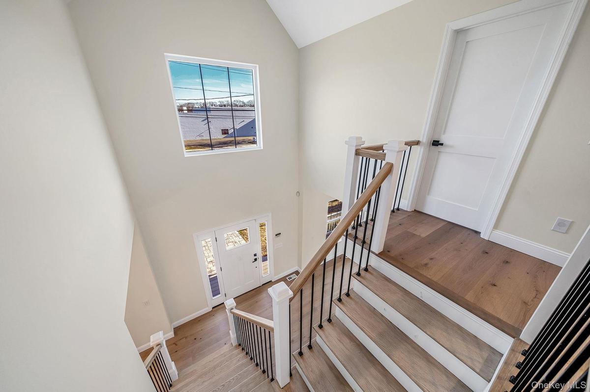 Stairway featuring wood-type flooring and a towering ceiling. For Marketing Purposes!