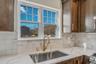 Kitchen with light stone counters and decorative backsplash. For Marketing Purposes!