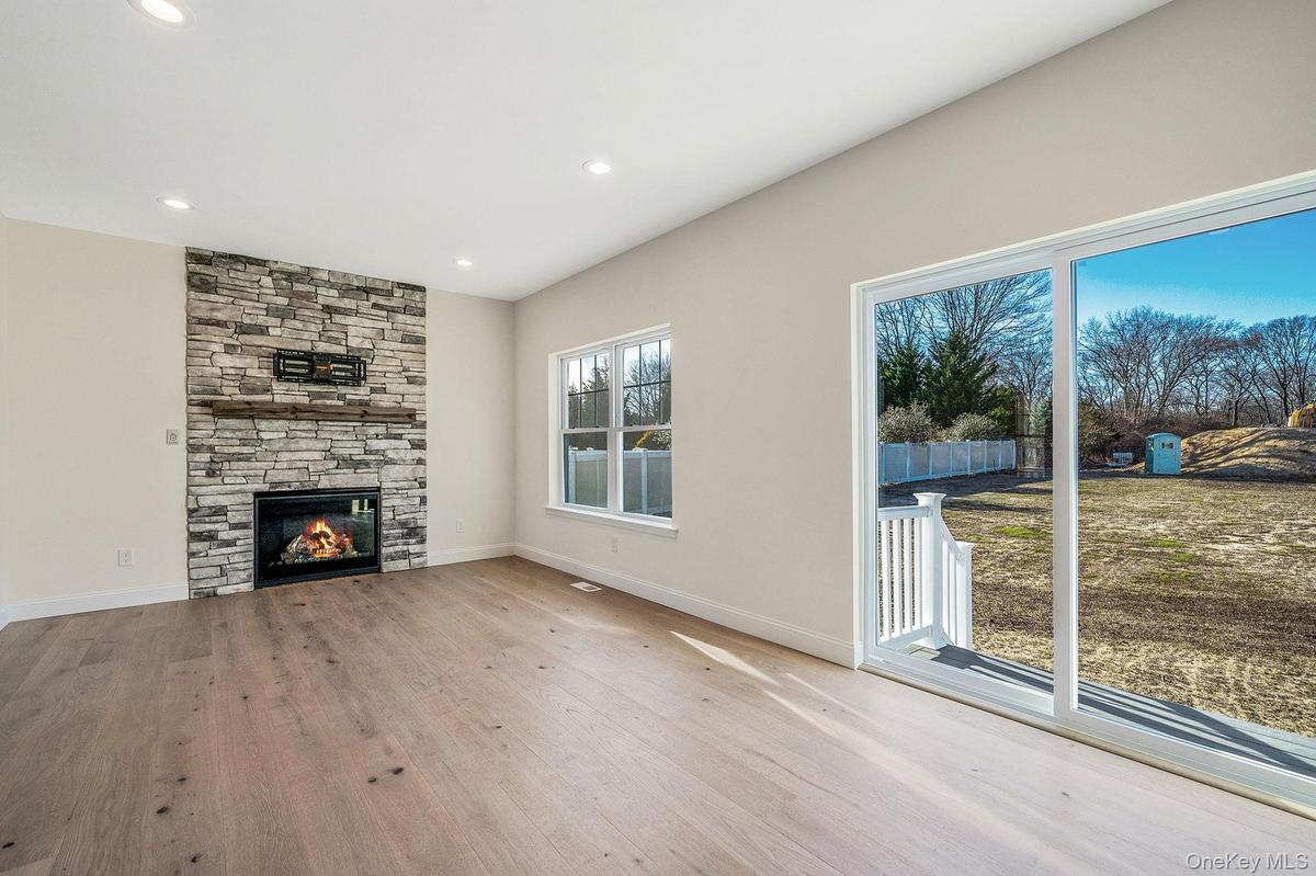 Unfurnished living room with light wood-type flooring, a fireplace, and recessed lighting. For Marketing Purposes!