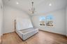 Bedroom with light wood-style flooring, vaulted ceiling, a chandelier, and recessed lighting. For Marketing Purposes!