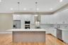Kitchen featuring appliances with stainless steel finishes, a kitchen island, tasteful backsplash, white cabinets, and recessed lighting. For Marketin