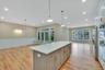 Kitchen with a decorative wall, decorative light fixtures, open floor plan, crown molding, and wainscoting. For Marketing Purposes!