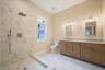 Full bathroom featuring double vanity, a marble finish shower, and light marble finish floors. For Marketing Purposes!