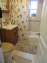 Bathroom with vanity, shower / bath combination with curtain, and light tile patterned flooring