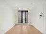 Spare room with a wall of windows, light wood finished floors, recessed lighting, and a view of city