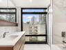 Bathroom with a view of city, vanity, light marble finish floors, walk in shower, and a bathtub