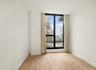 Spare room featuring a wall of windows, light wood-style flooring, and a city view