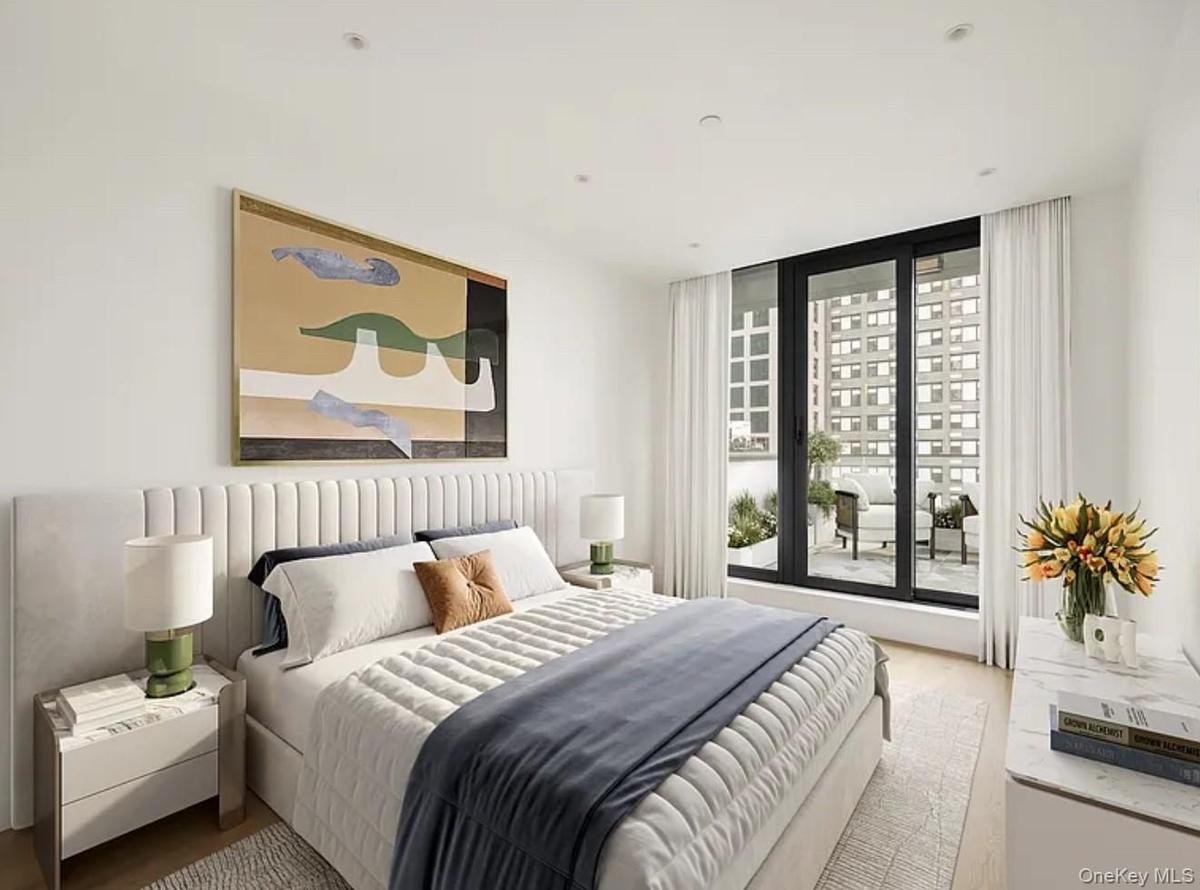 Bedroom featuring a wall of windows and wood finished floors