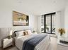 Bedroom featuring a wall of windows and wood finished floors