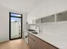 Kitchen featuring modern cabinets, appliances with stainless steel finishes, light wood-style floors, and light stone countertops
