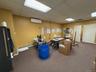 Carpeted office featuring a paneled ceiling, an AC wall unit, and a baseboard heating unit