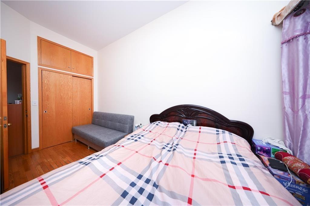 Bedroom featuring wood finished floors, lofted ceiling, and a closet