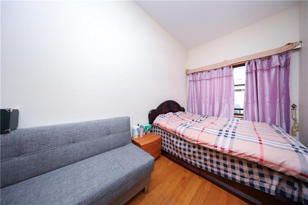 Bedroom with wood finished floors and lofted ceiling