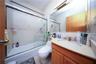 Full bathroom with toilet, vanity, and shower / bath combination with glass door