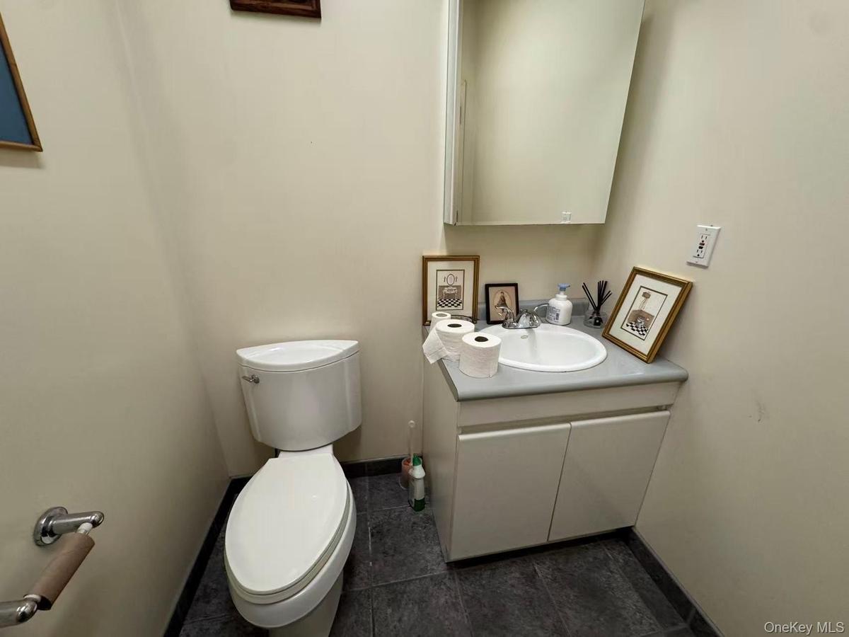 Half bath with vanity and dark tile patterned flooring