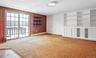 Family room with built in features, wet bar, light carpet, a baseboard radiator, a textured ceiling, and wooden walls