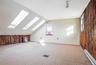 Bonus room with wooden walls, baseboard heating, lofted ceiling, carpet flooring, and a skylight
