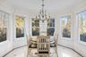 Sunroom / solarium with inlaid floor details, a chandelier, and ornamental molding