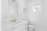 Half bathroom featuring vanity and marble look tile flooring