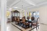 Dining area with crown molding, coffered ceiling, beam ceiling, a water view, and a chandelier