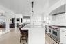 Kitchen with white cabinetry, a kitchen breakfast bar, high quality appliances, a kitchen island with sink, and wooden ceiling