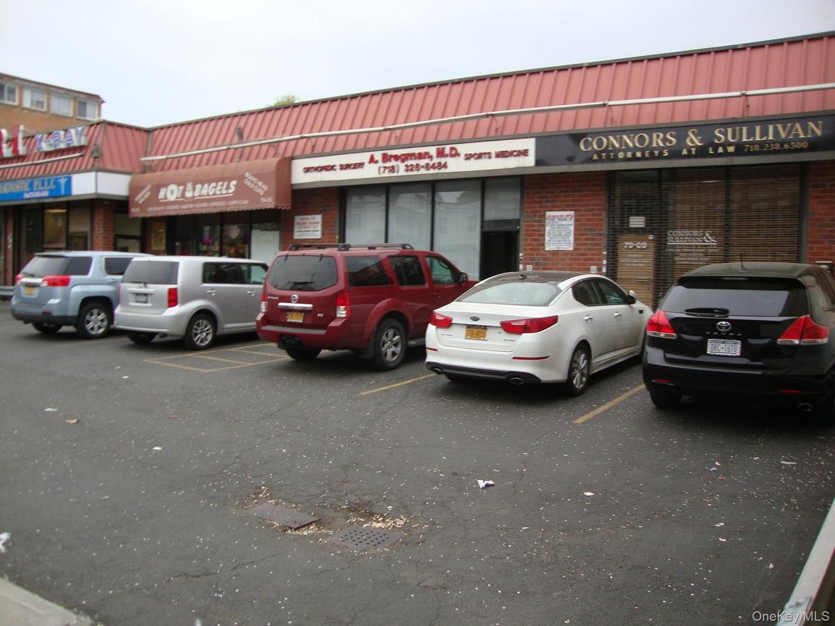 View of commercial property featuring uncovered parking