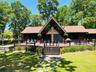 Log home featuring log siding, a front lawn, and a wooden deck