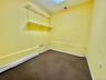 Laundry area featuring a baseboard radiator, dark carpet, and a skylight