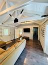 Living area featuring dark wood finished floors, log walls, and wooden ceiling