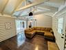 Living area featuring a barn door, log walls, hardwood / wood-style floors, and wooden ceiling