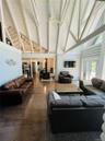 Living area featuring high vaulted ceiling, beam ceiling, hardwood / wood-style flooring, and a wood stove