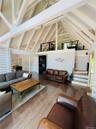 Living area featuring high vaulted ceiling, beam ceiling, and wood finished floors