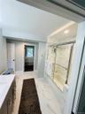 Full bath featuring vanity, light marble finish flooring, shower / bath combination with glass door, and recessed lighting
