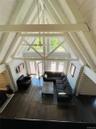Living area featuring dark wood-style flooring, high vaulted ceiling, and a wooden ceiling with exposed beams