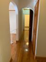 Corridor with hardwood / wood-style flooring and arched walkways