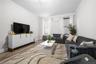 Living room with crown molding, wood finished floors, and radiator